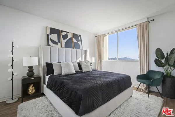 a bed sitting in a bedroom next to a window