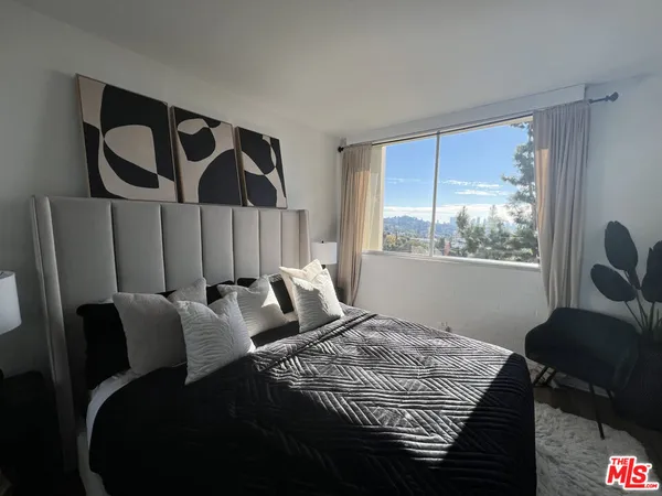 a bedroom with a large bed and a chandelier