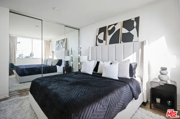 a living room with a couch next to a window with wooden floor