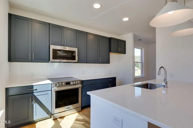 a kitchen with stainless steel appliances wooden cabinets and a stove top oven
