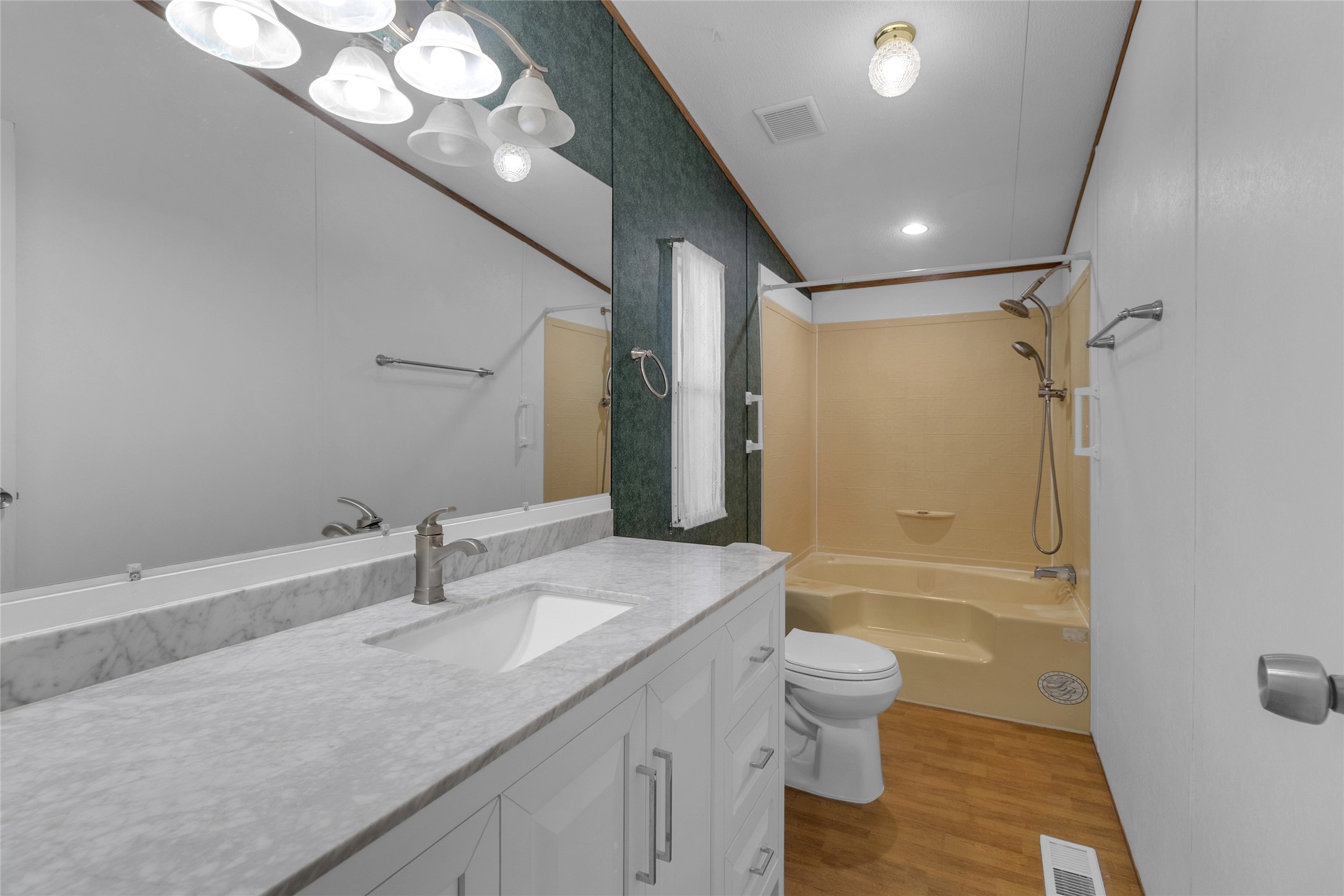 22094 Spear Road Porter, TX 77365 - Photo 23 of 45 This bathroom features a clean, modern design with a white vanity and granite countertop, complemented by a large mirror and overhead lighting. It includes a bathtub with a shower.