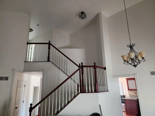 a view of staircase with wooden floor and fan