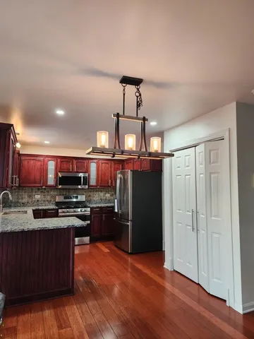 a kitchen with stainless steel appliances granite countertop a stove cabinets and refrigerator