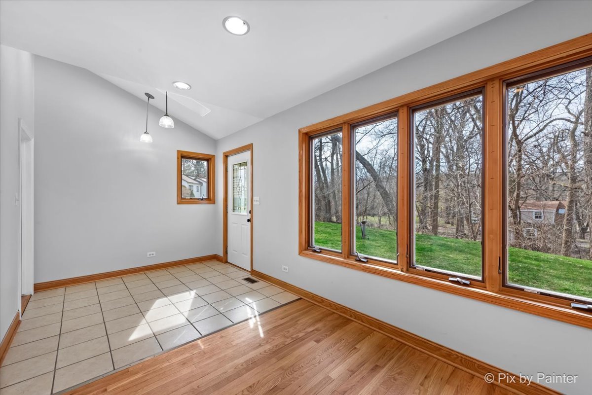 7611 Beverly Way Spring Grove, IL 60081 - Photo 11 of 33 wooden floor in an empty room with a window