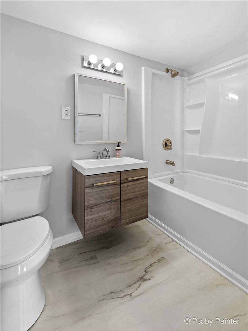 7611 Beverly Way Spring Grove, IL 60081 - Photo 16 of 33 a bathroom with a sink a toilet and bathtub