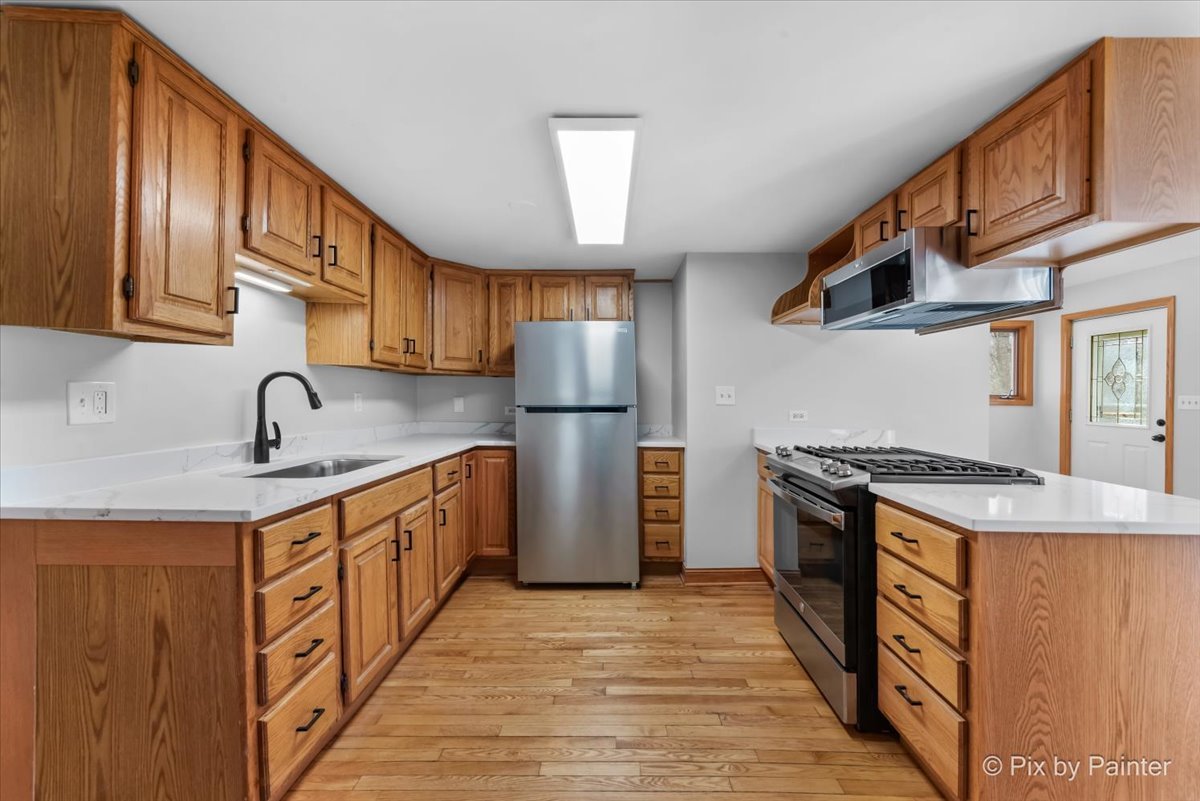 7611 Beverly Way Spring Grove, IL 60081 - Photo 4 of 33 a kitchen with stainless steel appliances granite countertop a stove and a sink