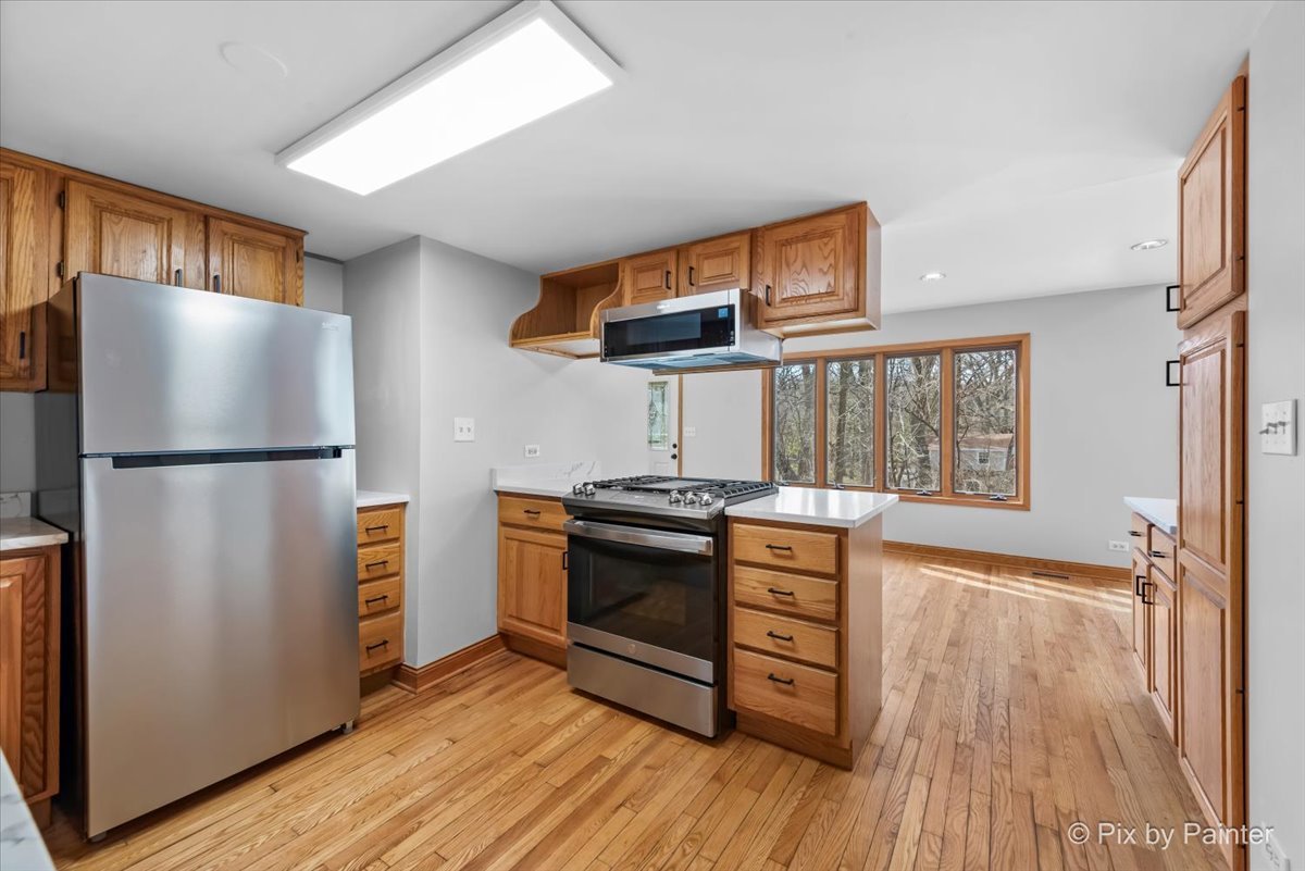7611 Beverly Way Spring Grove, IL 60081 - Photo 5 of 33 a kitchen with stainless steel appliances granite countertop a refrigerator and a stove top oven