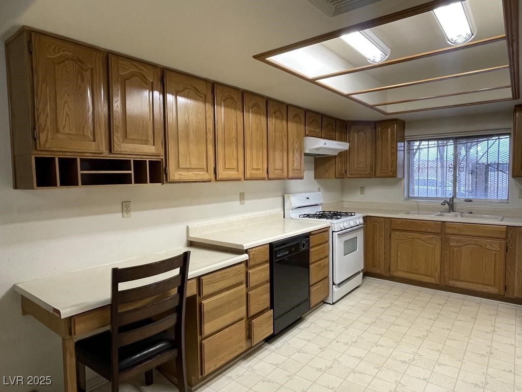 3530 North Pecos Road Las Vegas, NV 89115 - Photo 21 of 46 Kitchen with under cabinet range hood, white range with gas stovetop, a sink, dishwasher, and light floors