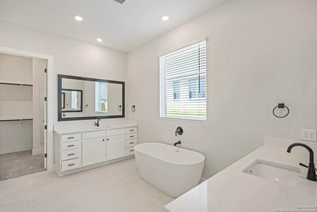 a bathroom with a bathtub sink and mirror