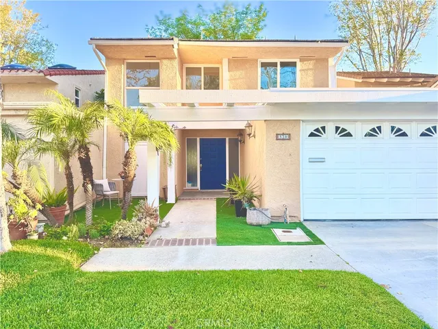 a front view of a house with a yard and potted plants