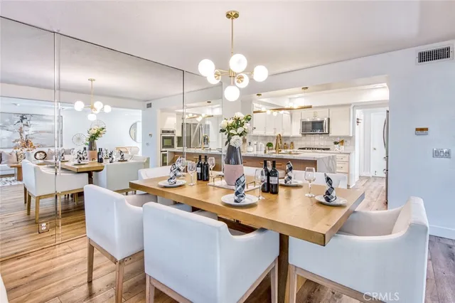 a dining room filled chandelier and kitchen view