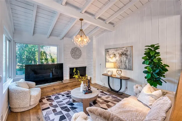 a living room with furniture a fireplace and a potted plant