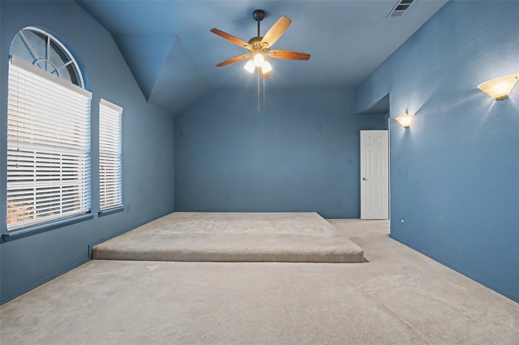 4902 Spring Lake Parkway Mansfield, TX 76063 - Photo 27 of 38 a bedroom with a bed and a chandelier