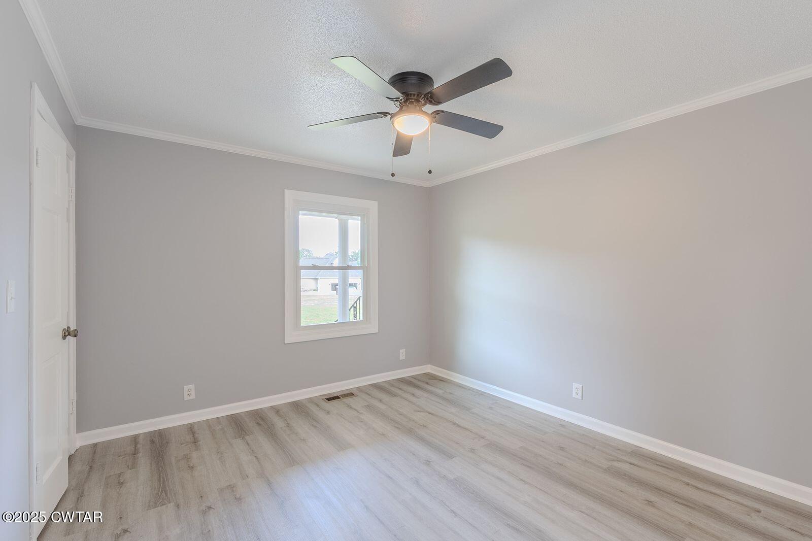 77 Upper Zion Road Brownsville, TN 38012 - Photo 16 of 27 an empty room with wooden floor fan and windows