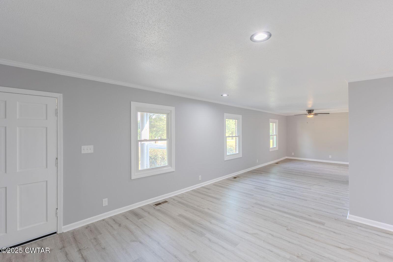 77 Upper Zion Road Brownsville, TN 38012 - Photo 3 of 27 an empty room with wooden floor and windows