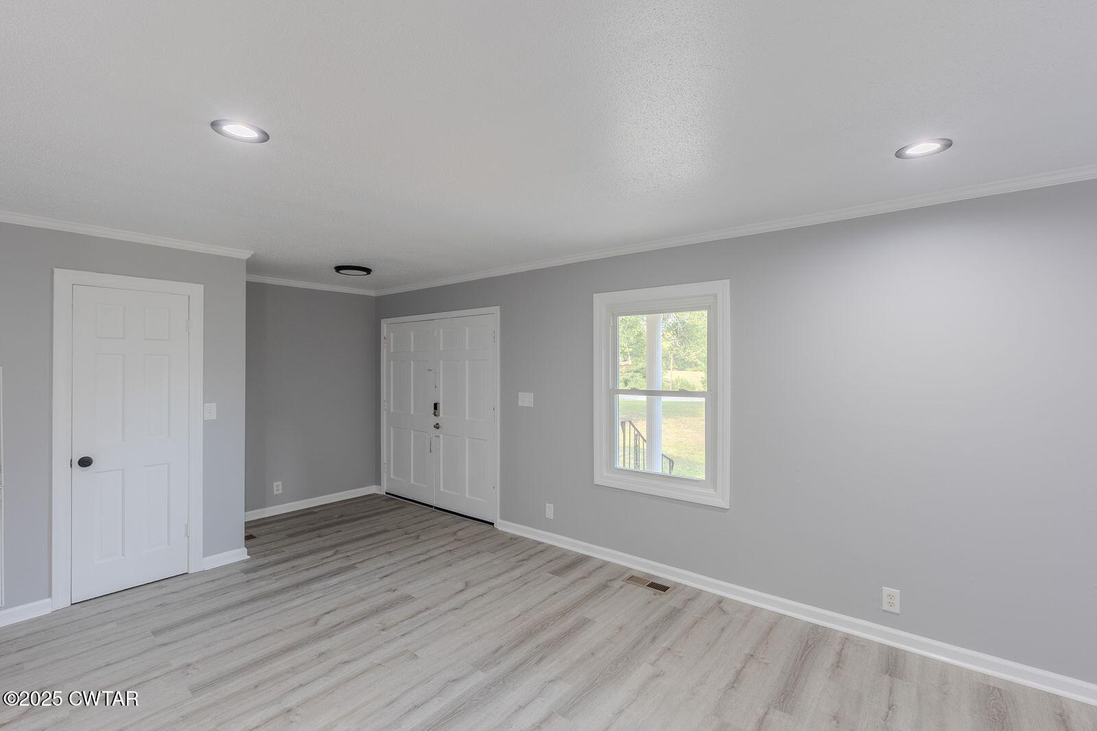 77 Upper Zion Road Brownsville, TN 38012 - Photo 5 of 27 a view of an empty room with wooden floor and a window