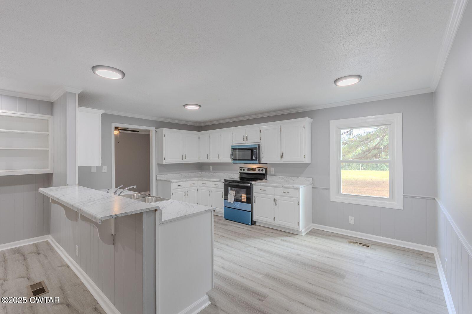 77 Upper Zion Road Brownsville, TN 38012 - Photo 8 of 27 a kitchen with a stove a sink and a refrigerator