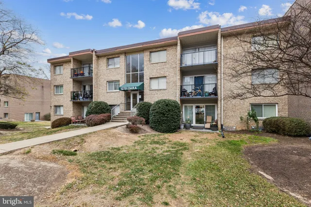a front view of a house with a yard and potted plants