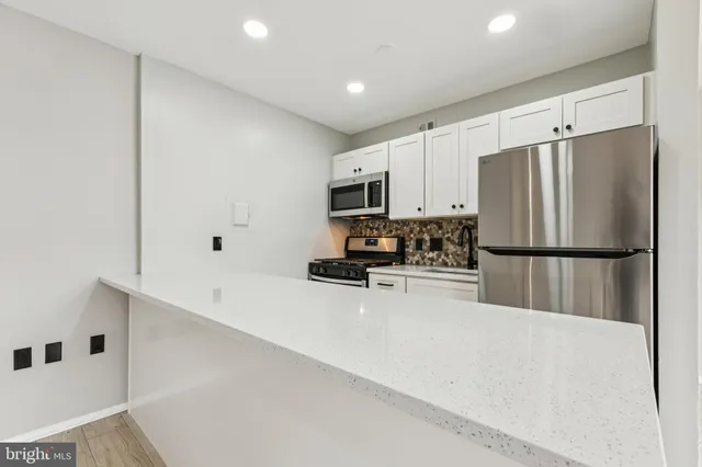 a kitchen with refrigerator a microwave and cabinets