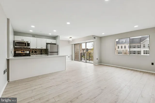 a view of kitchen with stainless steel appliances refrigerator oven and cabinets