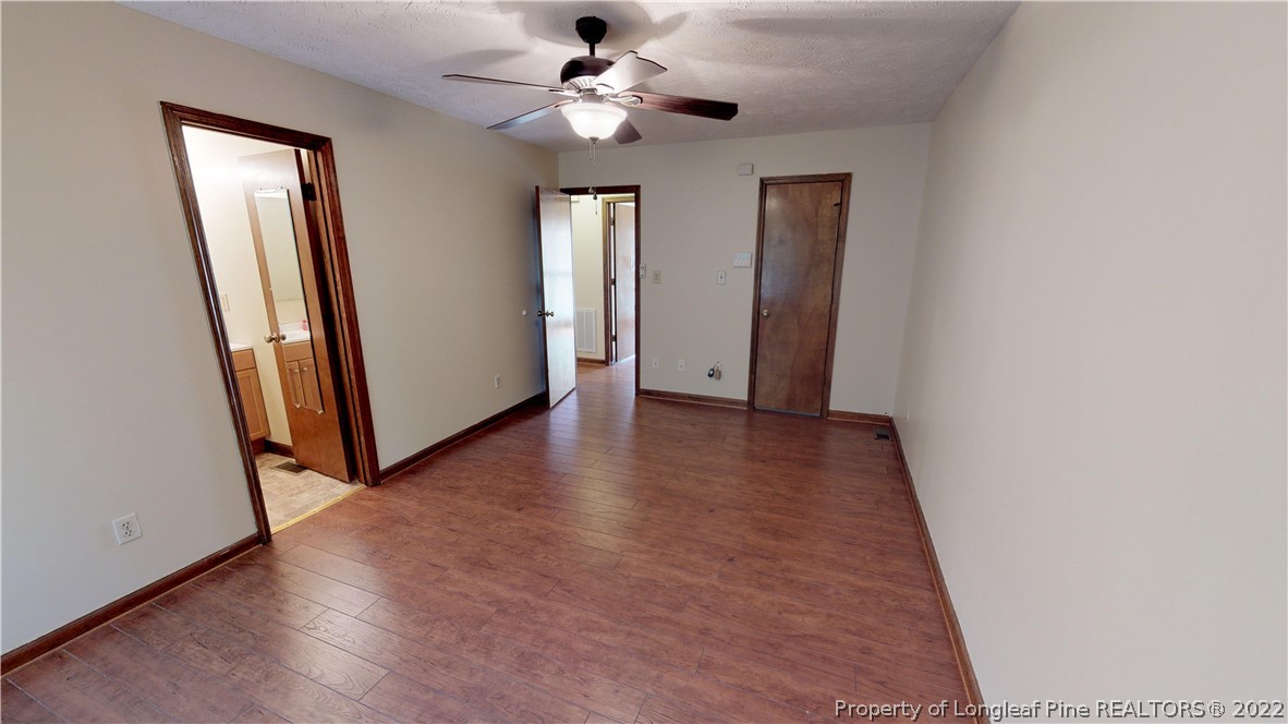 508 Jennings Farm Road Fayetteville, NC 28314 - Photo 11 of 24 an empty room with wooden floor and ceiling fan