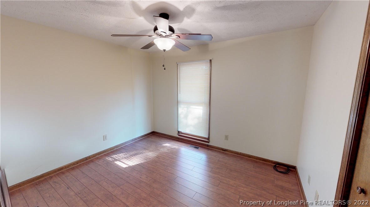 508 Jennings Farm Road Fayetteville, NC 28314 - Photo 17 of 24 an empty room with wooden floor and chandelier fan