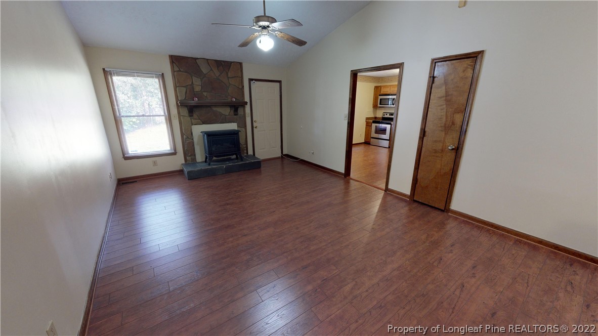 508 Jennings Farm Road Fayetteville, NC 28314 - Photo 9 of 24 an empty room with wooden floor fireplace and windows