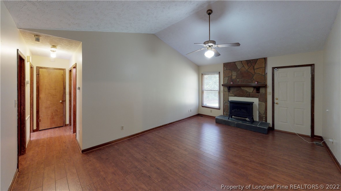 508 Jennings Farm Road Fayetteville, NC 28314 - Photo 10 of 24 an empty room with wooden floor fireplace and cabinet