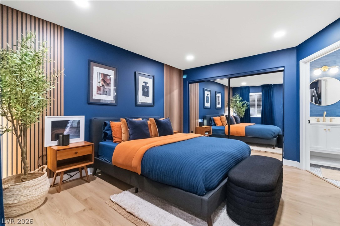 7950 West Flamingo Road, Unit 1180 Las Vegas, NV 89147 - Photo 15 of 26 Hardwood floors and sleek built-in mirror closet doors adorn this vibrant, well-lit bedroom space.