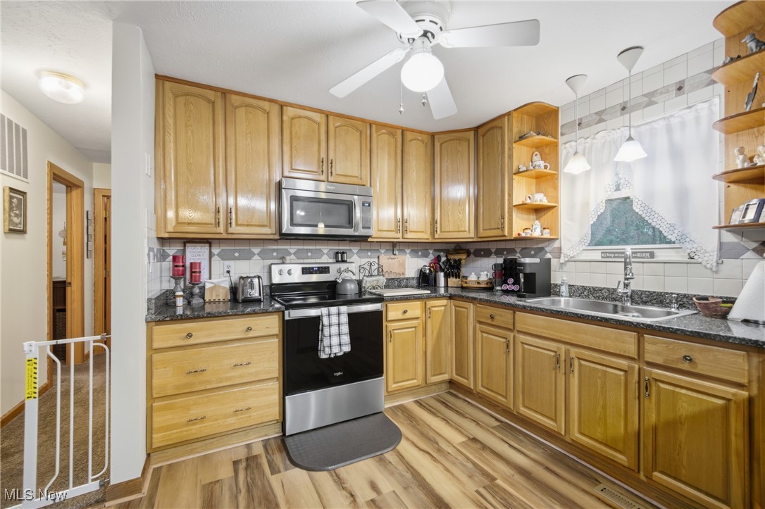 1788 Ashby Ridge Road Parkersburg, WV 26104 - Photo 14 of 46 Kitchen with appliances with stainless steel finishes, decorative backsplash, light wood finished floors, hanging light fixtures, and open shelves