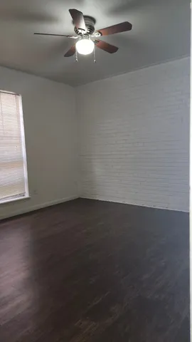 en empty room with wooden floor and windows