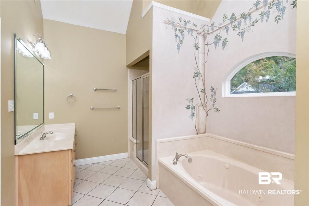8837 Dawes Lake Road South Mobile, AL 36619 - Photo 19 of 44 Bathroom featuring vanity, vaulted ceiling, independent shower and bath, and tile patterned flooring