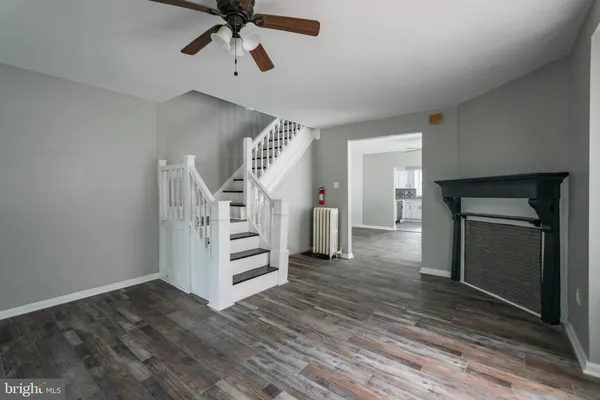 a view of a livingroom with wooden floor and a ceiling fan