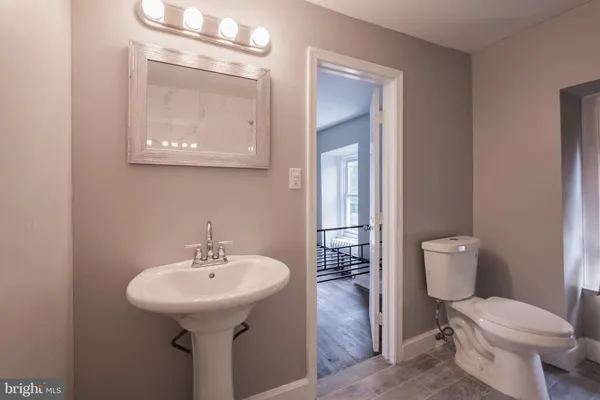 a bathroom with a toilet sink and mirror