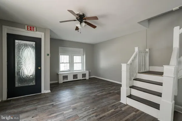 a view of a livingroom with wooden floor and a ceiling fan