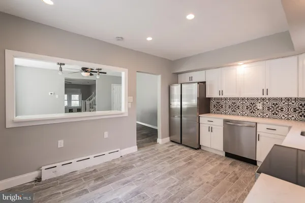 a large kitchen with stainless steel appliances granite countertop a refrigerator and a sink