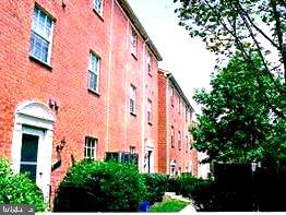 a front view of a multi story building with yard