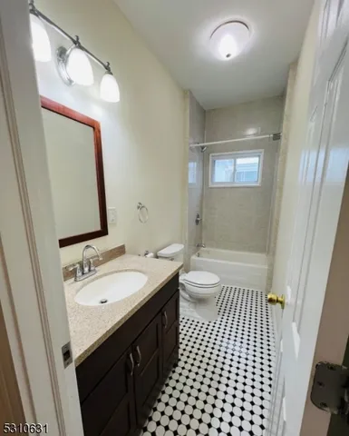 a bathroom with a sink a toilet a mirror and shower