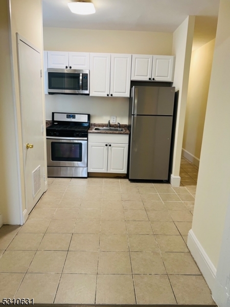 31 Elm Street, Unit 31C Westfield, NJ 07090 - Photo 5 of 8 a kitchen with a sink a stove top oven and refrigerator