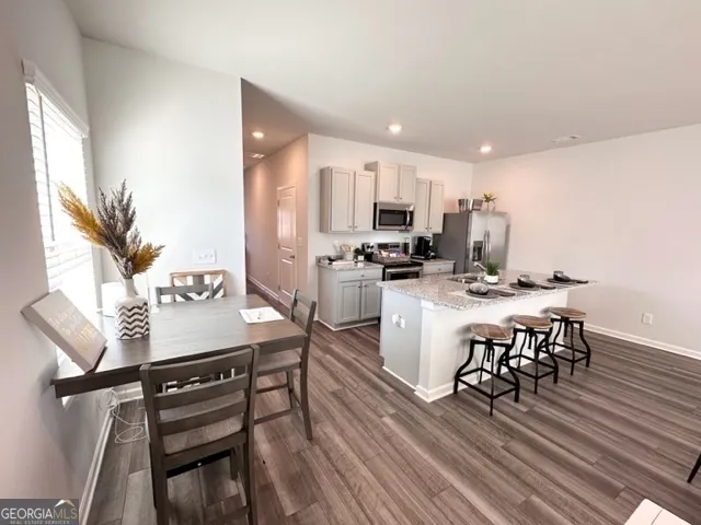 a kitchen with a table chairs microwave and cabinets
