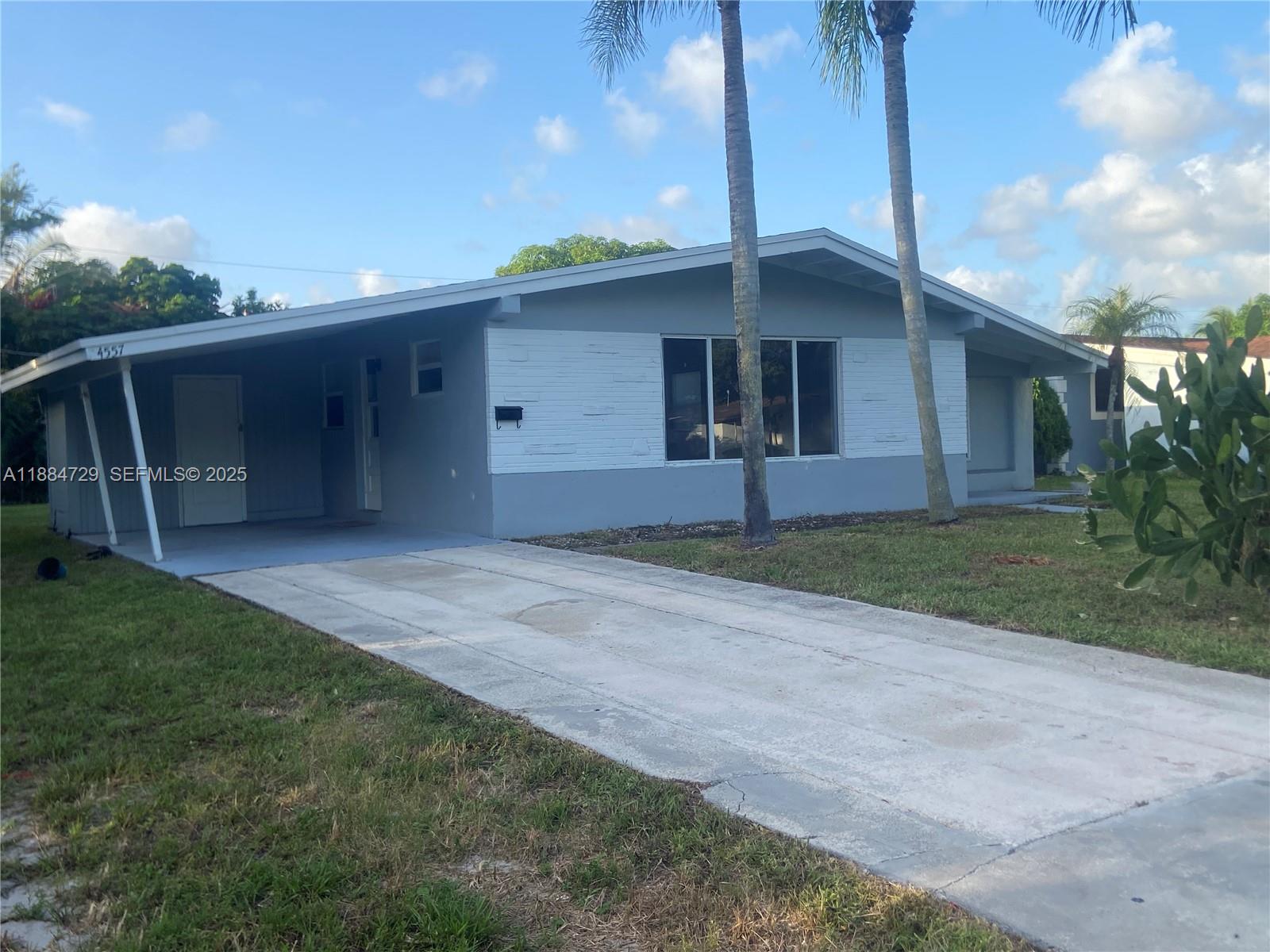 4557 Northwest 3rd Street Plantation, FL 33317 - Photo 1 of 11 a front view of house with yard and trees