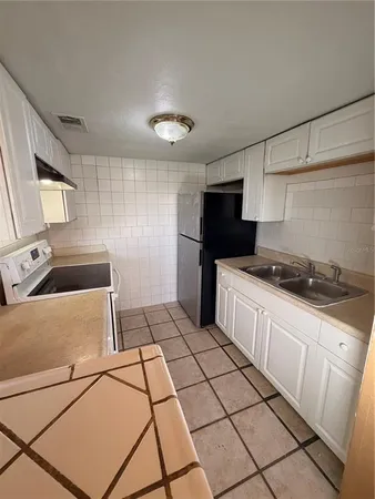 a kitchen with stainless steel appliances a stove a sink and a refrigerator