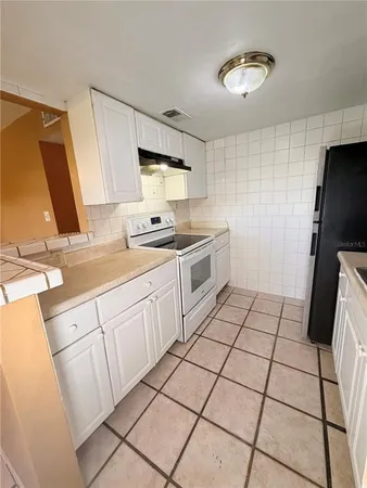 a kitchen with a sink a stove cabinetry and storage