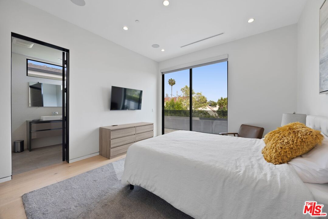 839 North Spaulding Avenue Los Angeles, CA 90046 - Photo 34 of 46 a bedroom with a large bed and a flat tv screen
