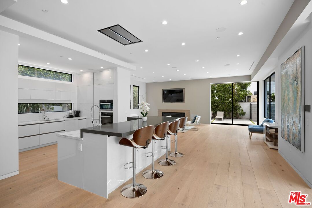 839 North Spaulding Avenue Los Angeles, CA 90046 - Photo 8 of 46 a view of a kitchen with kitchen island stainless steel appliances wooden floor and a large window