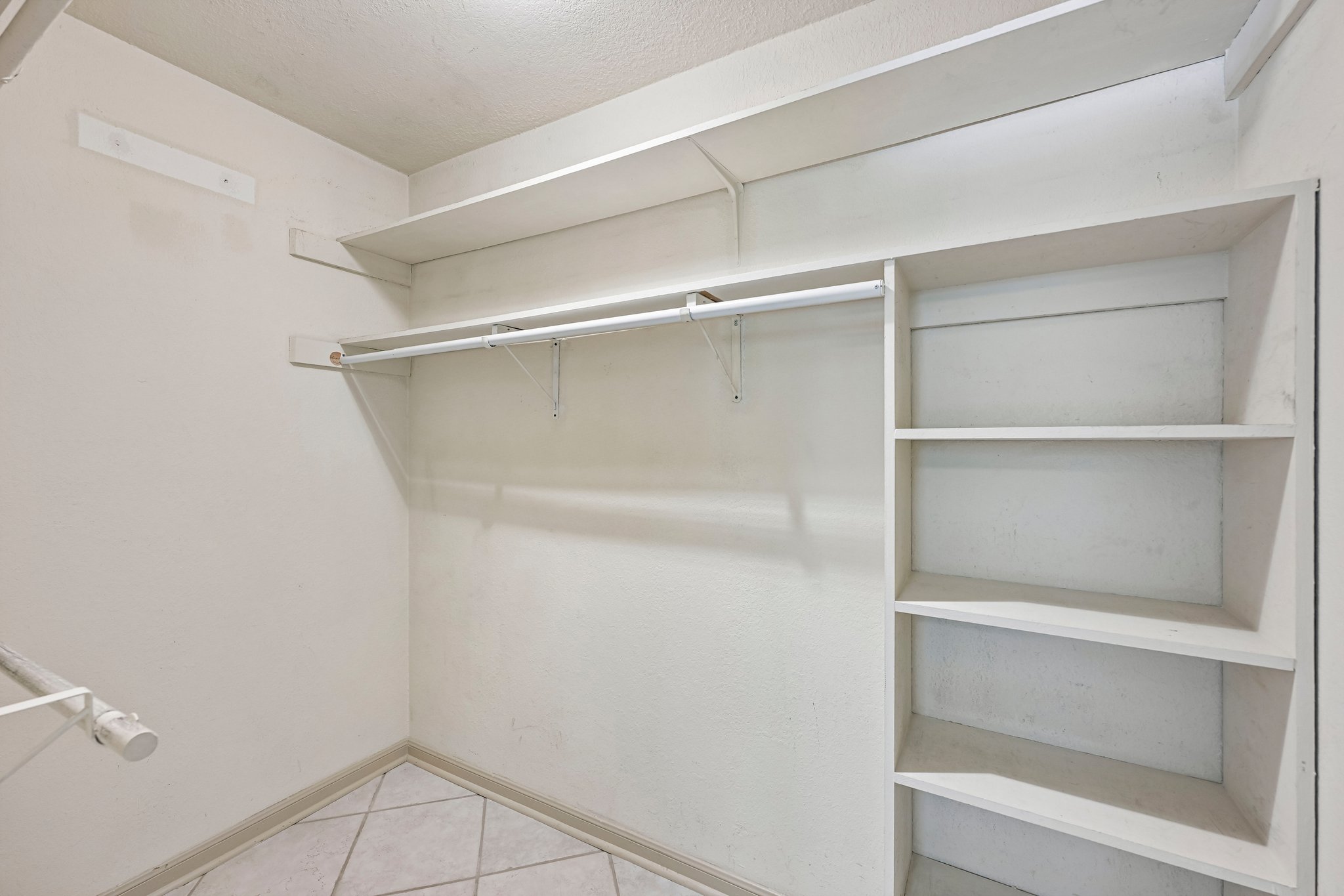2412 Enfield Road, Unit 8 Austin, TX 78703 - Photo 7 of 34 Built-in shelving and plenty of hanging space keep the bedroom cute and the wardrobe situation under control.