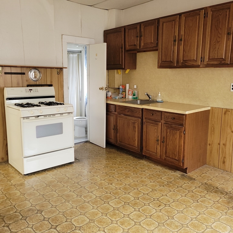 467 East 3rd Street Boston, MA 02127 - Photo 6 of 18 a kitchen with granite countertop a stove top oven sink and cabinets