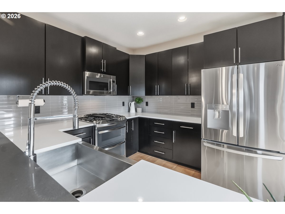 11375 Southwest Barber Street Wilsonville, OR 97070 - Photo 11 of 26 a kitchen with kitchen island granite countertop stainless steel appliances and sink