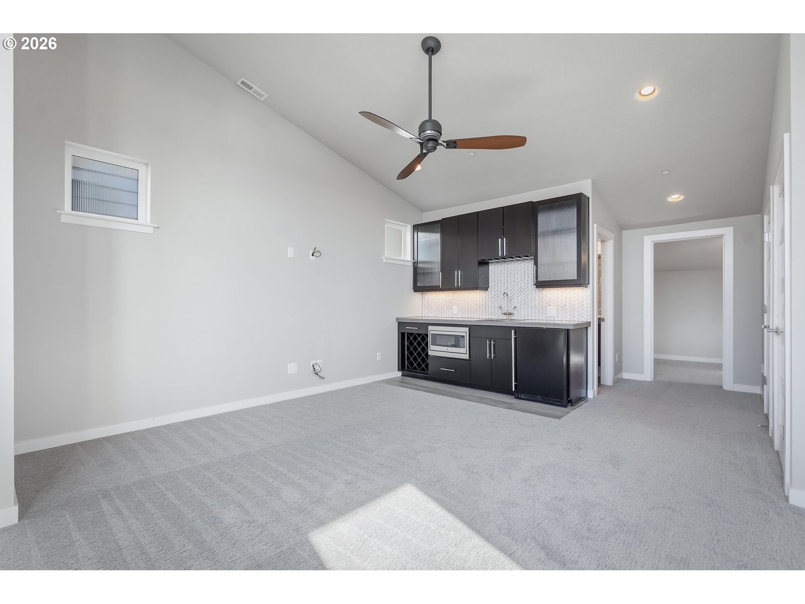 11375 Southwest Barber Street Wilsonville, OR 97070 - Photo 22 of 26 a living room with stainless steel appliances kitchen island a fireplace furniture a sink and a window