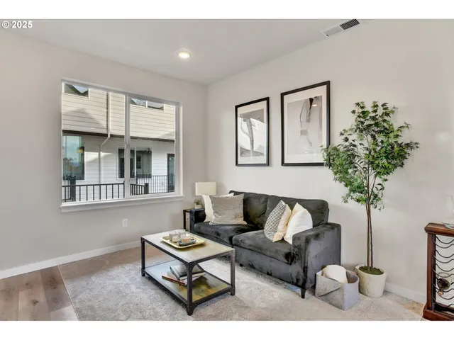 a living room with furniture a potted plant and a window
